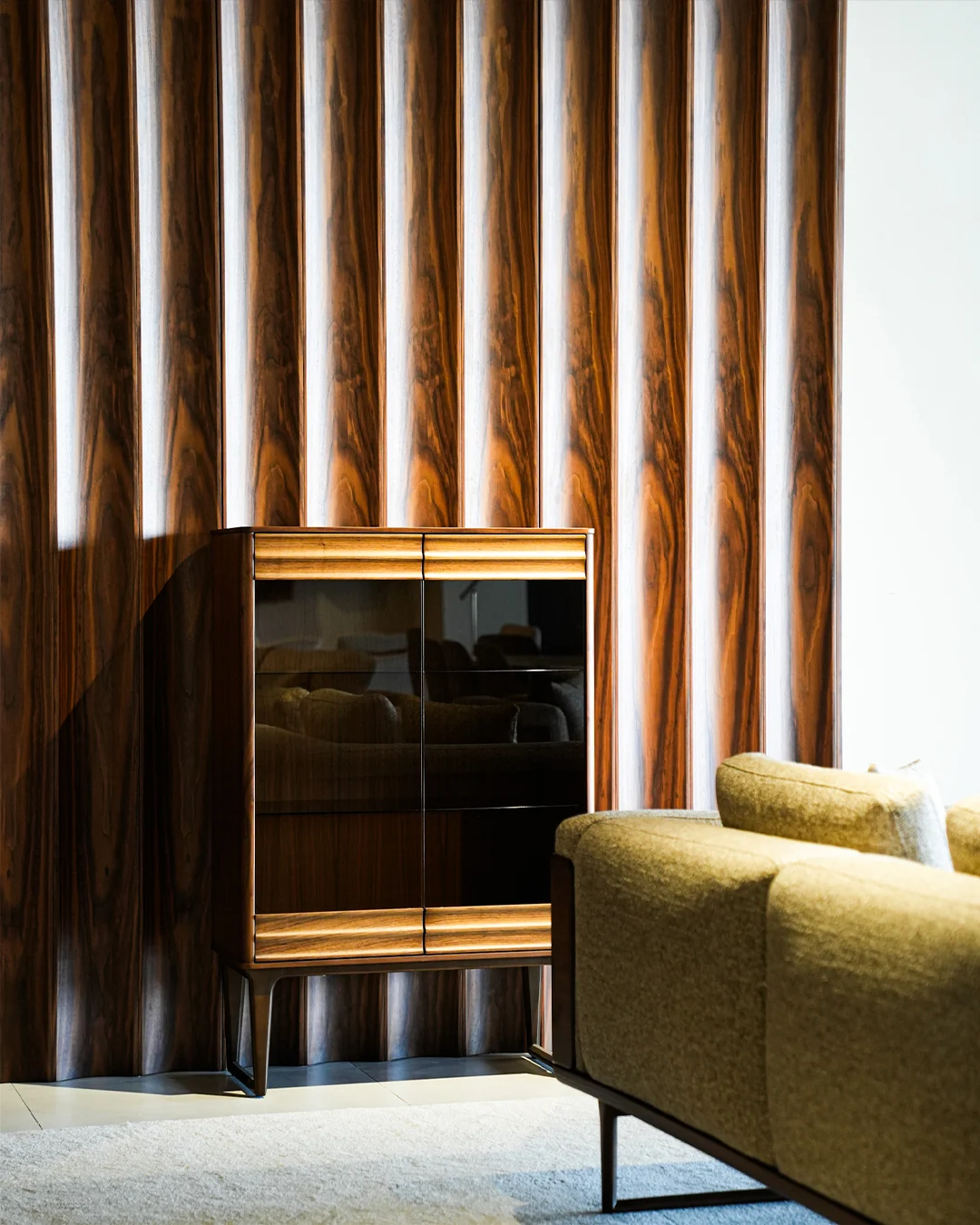 Warm timber, a contemporary side cabinet and green upholstery